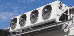Air con units on roof of building with blue sky